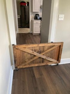 an open door leading into a kitchen with wood floors