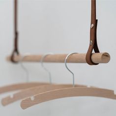 three wooden clothes hangers with metal hooks