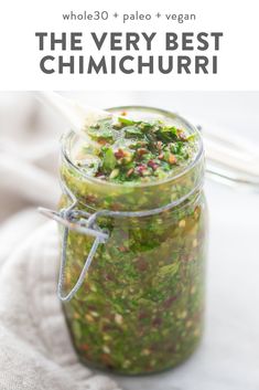 a jar filled with food sitting on top of a white cloth next to a spoon