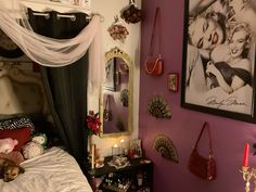 a bedroom decorated in pink and black with pictures on the wall, candles, and jewelry