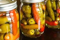 several jars filled with pickles and peppers