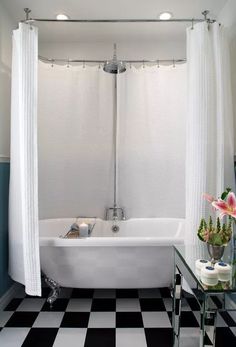 a white bath tub sitting next to a black and white checkered floor