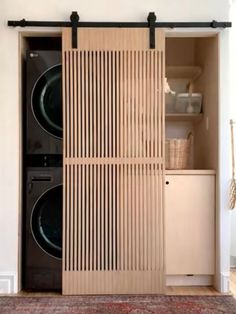 a washer and dryer in a room with wooden slats on the doors