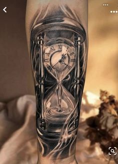 a man's leg with an hourglass tattoo on it