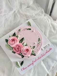 a cake decorated with pink roses and green leaves