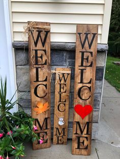 three wooden signs that say welcome, welcome home and pumpkins on the front porch