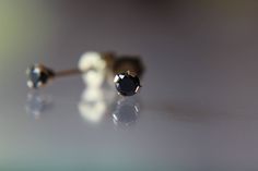 "An modern take on the classic diamond stud! Petite and minimalist, these genuine black diamond studs are great for subtle everyday wear or for second piercings. -Genuine black diamonds set in 14K yellow gold. -Total diamond weight of 0.20 carats. -2.8mm in diameter. -Solid 14K gold posts and friction backs. These black diamond studs will come to you nicely packaged and gift wrapped. All metals are recycled and refined and diamonds & gemstones are ethically sourced as well. ★ IMPORTANT SHIPP Second Piercings, Black Diamond Earrings Studs, Gemstone Stacking Ring, Iolite Stone, Black Diamond Studs, Second Piercing, Black Diamond Earrings, Natural Gemstone Ring, Diamond Earring