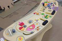 a toy table with many different items on it and some cardboard boxes in the background