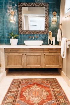 a bathroom with a rug, sink and mirror on the wall next to each other