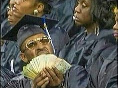 a group of people in graduation gowns holding money