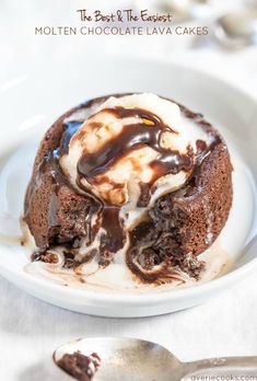 a white plate topped with a chocolate lava cake covered in melted chocolate and ice cream