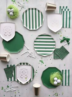 green and white paper plates, napkins, cups and spoons on a table