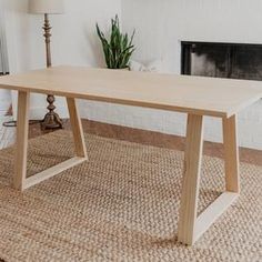 a wooden table sitting on top of a rug next to a fireplace