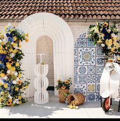 a white scooter parked next to a building with flowers on the outside wall