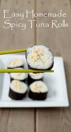 sushi rolls on a plate with chopsticks in the foreground and text overlay that reads easy homemade spicy tuna rolls