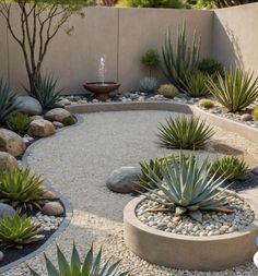 an outdoor garden with rocks, plants and water fountain in the center is surrounded by gravel