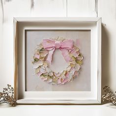 a white frame with a pink wreath on it