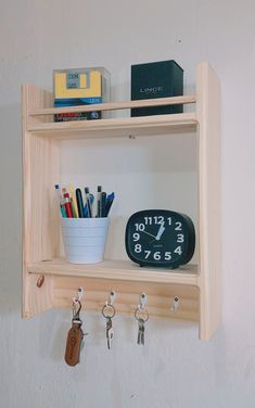 a wooden shelf with key hooks and a clock on the wall next to other items