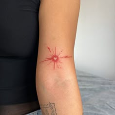 a woman's arm with a tattoo on it that has a star burst in the middle