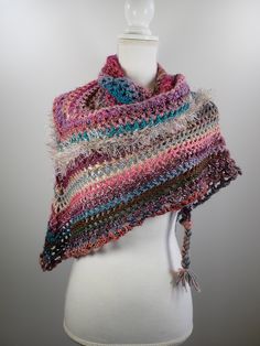 This cozy warm triangle scarf is hand crocheted and one of a kind. It is made with many different blends of yarn colors and content, including acrylic and wool. Primarily pink and teal, but other colors include green, purple, brown, burgundy and more. Embellished with braided yarn at the two ends. It is a great scarf for yourself or for a special person. It measures 69 inches at it's widest point and the sides measure 49 inches from the top point to the bottom point along the side of the scarf. Hand Knitted Multicolor Yarn Shawl, Bohemian Multicolor Shawl With Granny Square, Bohemian Multicolor Granny Square Shawl, Multicolor Crochet Yarn Shawl, Multicolor Crochet Shawl, Braided Yarn, Wool Cowl, Crocheted Scarf, Crochet Wool