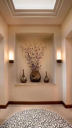 two vases with flowers are on the wall above a rug in an empty room