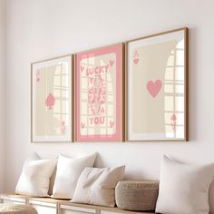 two framed pictures hang on the wall above a bench with pillows and throw pillows in front of them