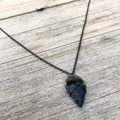 "Attract success and abundance in this minimalist wire-wrapped, arrowhead necklace. Makes a perfect Father's Day or graduation gift. It can be worn alone or layered for a modern boho look. Arrowhead is approximately 1\" (one inch) in length. Arrowheads are hand-knapped and vary slightly in size, shape and color. Each will have sight variations in texture and wire wrapping to accommodate individual characteristics. The chain is a nickel-free base metal, coated in black. This design is handmade by Handmade Sterling Silver Arrowhead Necklace, Adjustable Hand Forged Black Jewelry, Artisan Wire Wrapped Black Jewelry, Hand Forged Black Jewelry As Gift, Black Hand Forged Jewelry For Gift, Hand Forged Black Jewelry For Gift, Hand Forged Black Jewelry Gift, Artisan Black Wire Wrapped Jewelry, Artisan Hand Forged Black Jewelry