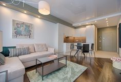 a living room filled with furniture next to a kitchen and dining room table on top of a hard wood floor