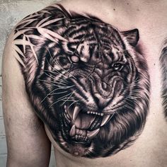 a man with a tiger tattoo on his chest and an animal behind him, both showing their teeth