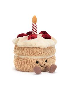 a stuffed animal sitting in front of a cake with a candle on it's top