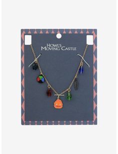 a necklace with charms hanging from it's side in front of a card board