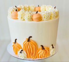 a white cake decorated with orange and white frosting pumpkins on top of it