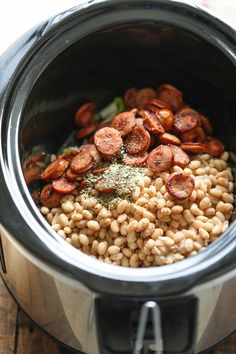 a crock pot filled with beans and sausage