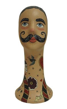 a wooden head with a mustache and flowers on it