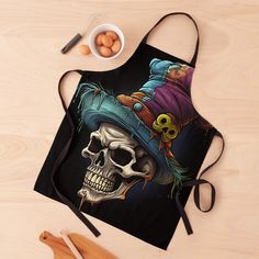 an apron with a skull wearing a top hat and holding a knife next to eggs