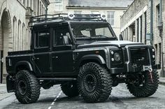 a black land rover is parked on the street