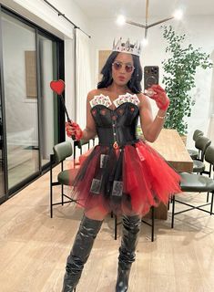 a woman in a black and red costume is taking a selfie