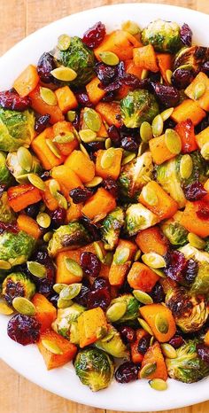 a white plate topped with brussel sprouts and sweet potatoes