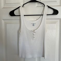 White Brandy Melville Bottom Up Tank, Never Worn, One Size Brandy Melville White Tank Top, White Brandy Melville Top, Casual Cotton Tank Top With Button Closure, Casual Cotton Tank Top With Buttons, Casual White Buttoned Tank Top, White Cotton Tank Top With Button Closure, White Cotton Tank Top With Buttons, White Cotton Buttoned Tank Top, Tops Brandy Melville