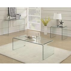 three glass tables sitting on top of a rug in front of a white wall and floor