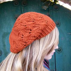 a woman with blonde hair wearing an orange knitted hat