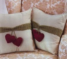 two pillows with hearts attached to them on a chair