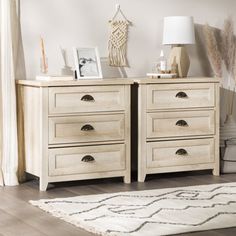 two white dressers sitting next to each other on top of a rug in a room