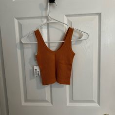 Brand New With The Tags Still On Affordable Summer Tank Top By Urban Outfitters, Casual Orange Seamless Tops, Urban Outfitters Brown Crop Top For Spring, Urban Outfitters Cotton Stretch Tank Top, Sleeveless Brown Top From Urban Outfitters, Urban Outfitters Sleeveless Spring Tank Top, Urban Outfitters Fitted Tank Top With Built-in Bra, Urban Outfitters Brown Sleeveless Top, Urban Outfitters Orange Sleeveless Top