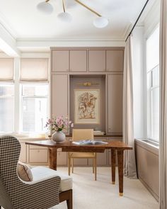 a room with a desk, chair, and window in it that has curtains on the windowsill