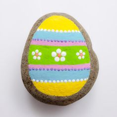 an easter egg painted on top of a rock