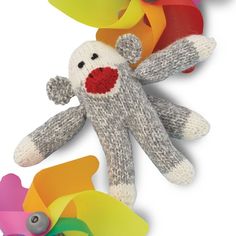 a stuffed animal is surrounded by colorful streamers and paper flowers on a white background