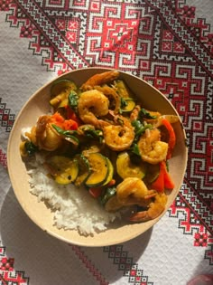 a bowl filled with shrimp and vegetables on top of rice