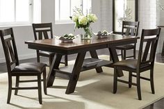 a dining room table and chairs with flowers in vase