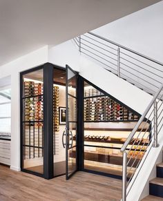 a wine store with stairs leading up to the second floor and glass doors that open